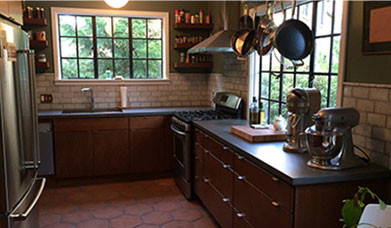 kitchen with dark countertops and light tile backsplash by class a construction