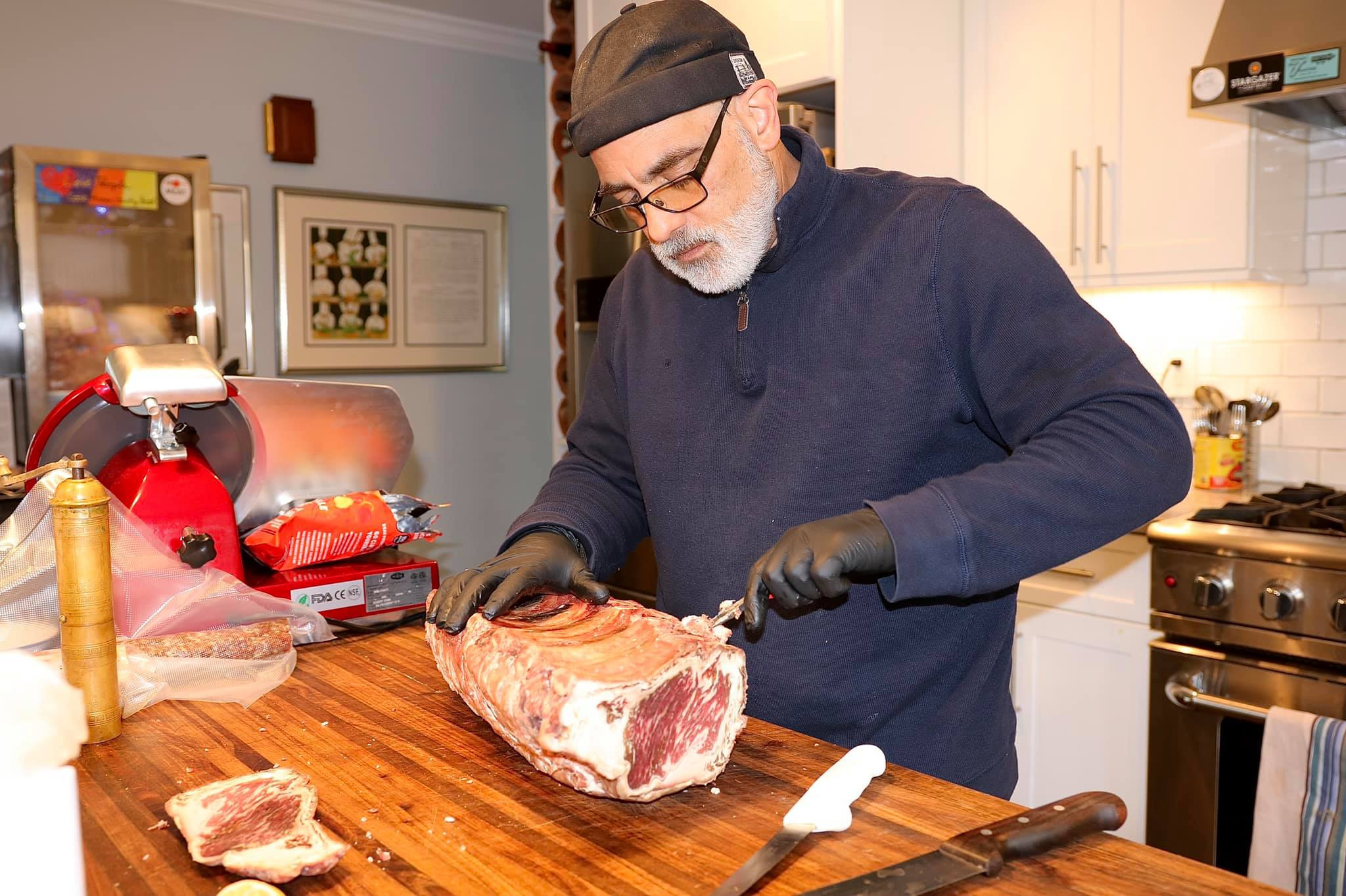 man cutting into a dry aged steak 