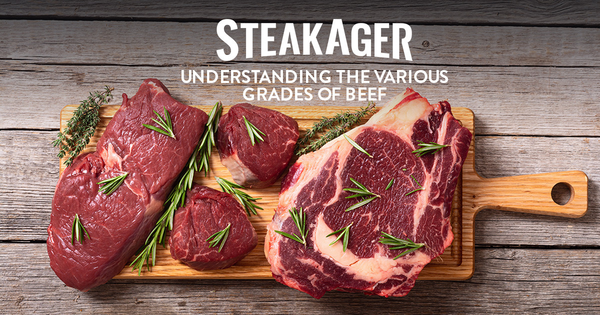 diffrent cuts of raw beef on wooden board with fresh herbs