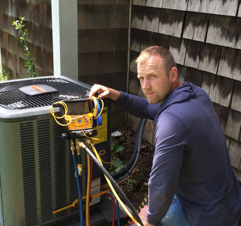 AV Enterprise technician repairing air conditioning unit in Rochester NY