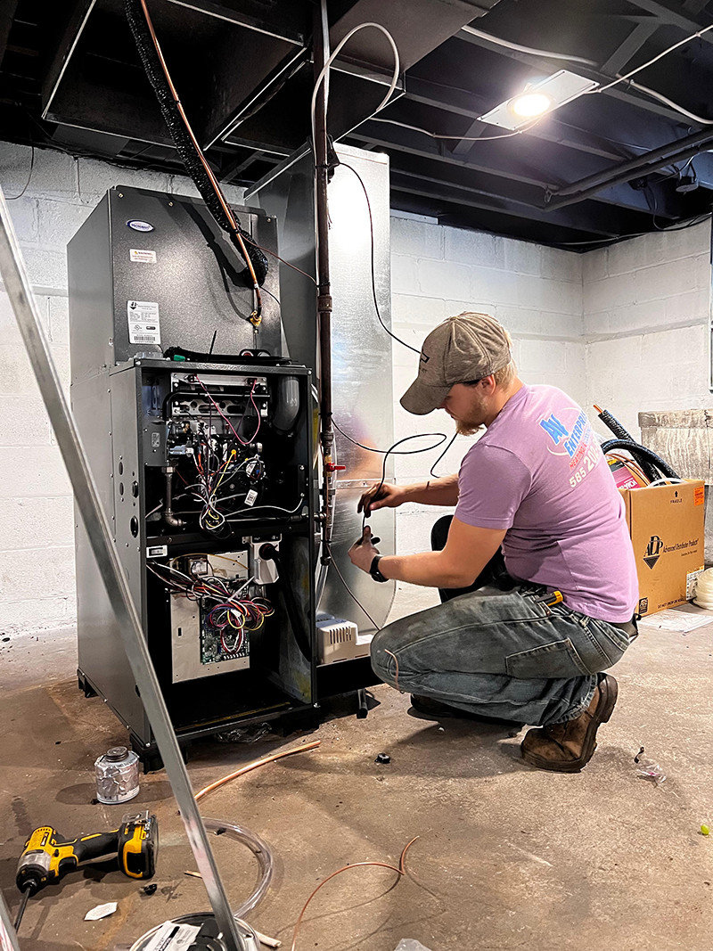 AV Enterprise technician servicing heating unit in residential basement