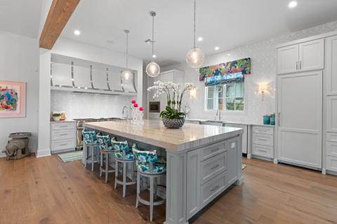 white tiled kitchen with island and blue chairs