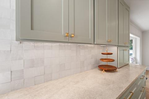 neutral tile backsplash with sage cabinets