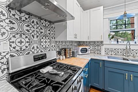 tile backsplash behind stove and blue cabinets